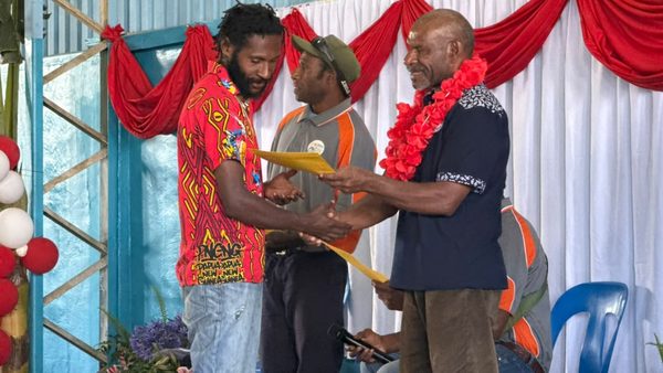 A graduate receives a certificate. Catholic Diocese of Goroka, YC Hall, Goroka, Eastern Highlands. September 2026.